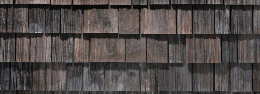 Close up of woodland shingles showcasing natural wood grain texture and varied earthy tones.